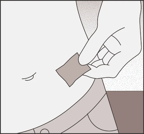 A hand holding a rectangular patch above the