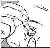 A hand holding a dropper bottle above the
