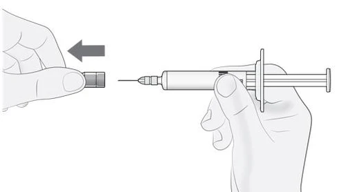 A hand holding a syringe while the