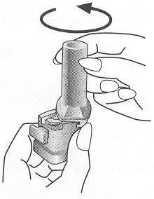 Dos manos sostienen un dispositivo médico cilíndrico mientras una flecha curva indica un movimiento de rotación hacia la izquierda