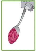 A hand holds a metal spoon containing a creamy substance with an intense pink color and a spiral texture
