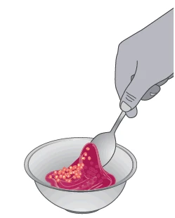 A hand holds a spoon scooping a thick, dark red substance from a small white bowl