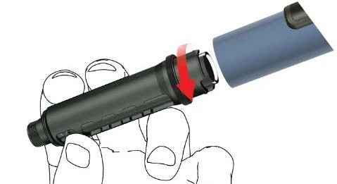 Una mano sostiene un dispositivo médico cilíndrico negro mientras una flecha roja indica la rotación de una tapa azul hacia la