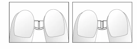 Two fingers firmly holding the central part of a small white medical device