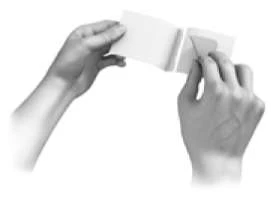 Due mani tengono e aprono un foglietto piegato con un movimento verso l'esterno per leggerne il contenuto interno