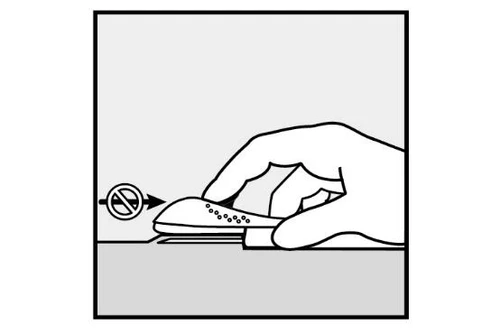 Una mano tiene un dispositivo medico su una superficie piana con un simbolo di divieto che indica di non applicare pressione sulla parte superiore