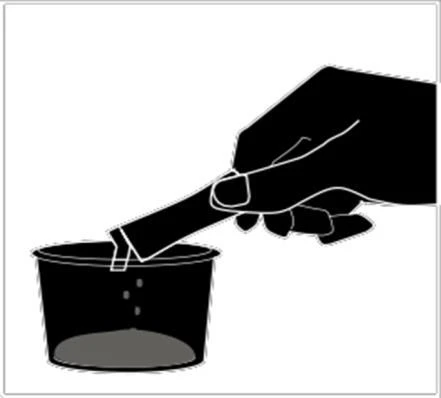 A hand holding a vial tilted to pour liquid contents into a small container or dark cup