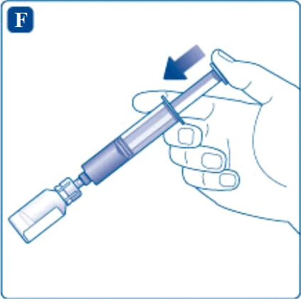 Una mano sostiene una jeringa inclinada para aspirar el contenido de un pequeño frasco de vidrio, con una flecha azul que indica el movimiento
