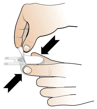 A hand pressing a white medical device against a person's finger