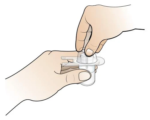 Two hands holding and manipulating a transparent cylindrical medical device with a flat base and a contoured upper part