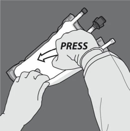Two hands firmly pressing the upper part of a white medical device with two black tubes to activate the mechanism indicated by the arrow