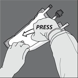 Two hands forcefully pressing the upper part of a medical bag containing tubes to push the contents downward
