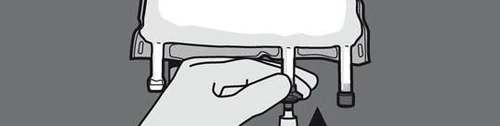 A hand pressing a button on a white medical device with two vertical rods on a dark gray background