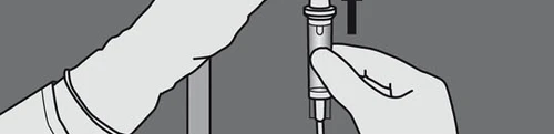 A hand holding an injection pen vertically while the