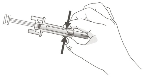 Una mano sujetando una jeringa precargada con los dedos, indicada por dos flechas negras que apuntan hacia el centro del dispositivo para mostrar la presión