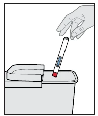 Una mano tiene una penna iniettiva bianca con finestra blu e punta rossa mentre la inserisce in un contenitore per lo smaltimento dei rifiuti