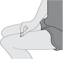 Illustrazione in scala di grigi che mostra una mano che applica una piccola striscia adesiva sulla parte superiore della coscia di una persona seduta