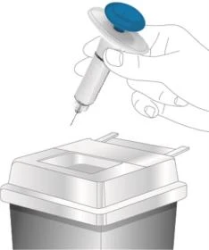 A hand holding an injection pen with a blue button above a disposal container for sharp objects and medical waste