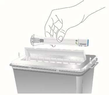 A hand holding a white injection pen bringing it close to a gray medical waste disposal container