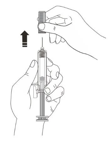 A hand removes the protective cap from the needle of a syringe held vertically
