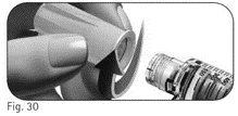 A hand removes the protective cap from a medical device next to a transparent syringe with a graduated scale
