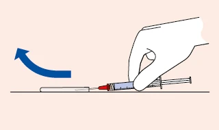 A gloved hand holding a syringe horizontally above a flat surface, with a curved blue arrow indicating an upward flicking motion