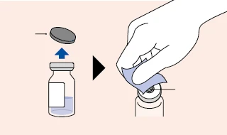 A hand removing a grey cap from a glass vial containing blue liquid, preparing it for