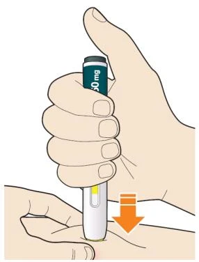 A hand gripping a green and white cylindrical medical device pressed against the arm skin with an orange arrow pointing downward