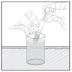 Two hands hold a syringe with needle and plunger to draw up liquid contained in