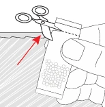 A hand holds a sachet containing small pills while scissors cut the upper edge of the container indicated by a red arrow