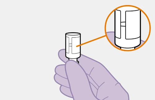 Una mano tiene un dispositivo medico cilindrico bianco con un dettaglio ingrandito in un cerchio arancione che mostra una fessura centrale