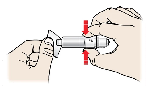 Two hands gripping a cylindrical medical device with red arrows indicating pressing fingers toward the center of the device body