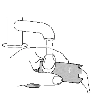 One hand holding a medical device while another hand performs an action