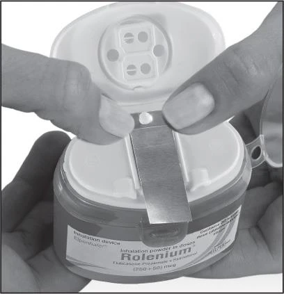 Due mani aprono il coperchio di un dispositivo di inalazione Rolenium con polvere contenente fluticasone e salmeterolo