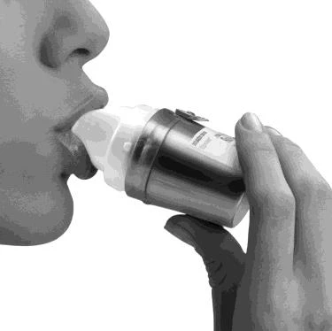 Profilo di una persona che tiene un flacone di medicinale con entrambe le mani e lo porta alla bocca per l'assunzione