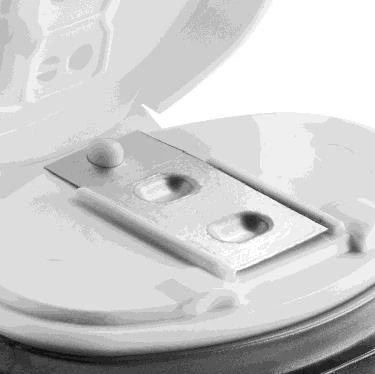 Un contenitore per oggetti taglienti aperto con un coperchio bianco e un inserto interno con due fori per lo smaltimento sicuro di aghi e siringhe