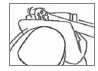Line drawing showing a person sitting with their back facing forward, hand resting on the upper part of the right thigh