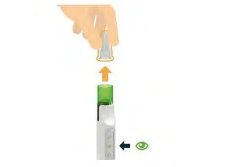 A hand lifting a transparent cap from a white medical device with a green indicator and an arrow pointing toward an eye