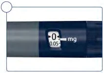 Detail of a medical device with a digital display showing a dose of 0.05 mg next to the abbreviation mg on a blue and gray background