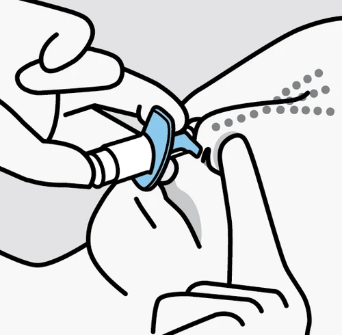 A hand holding a blue and white medical device to apply it to the skin of an arm while the