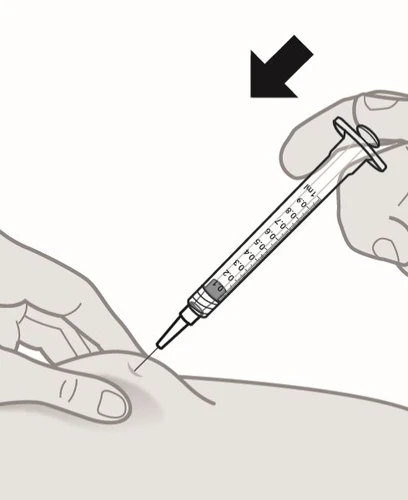 Una mano impugna una siringa graduata per iniettare il liquido nel braccio mentre l'altra mano tiene ferma la pelle con un dito
