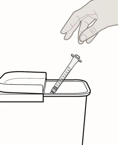Una mano che rilascia una siringa usata all'interno di un contenitore per lo smaltimento dei rifiuti taglienti e pericolosi