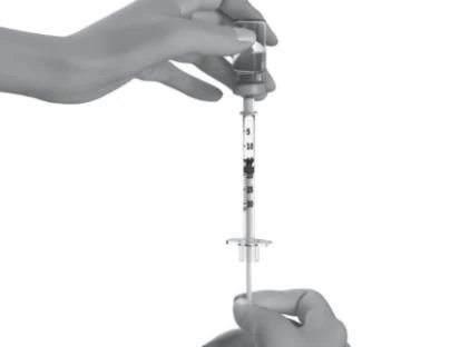 A hand holds the top part of a syringe while the