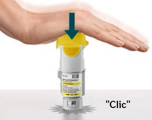 A hand firmly pressing a yellow and white medical device onto a white surface with a downward arrow and the word 'Click'
