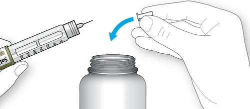 A hand holding a syringe with needle while the