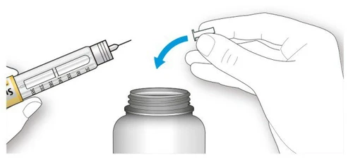A hand holding a syringe with needle while the