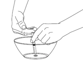 Two hands holding a syringe with a needle immersed in a bowl containing liquid to aspirate the contents