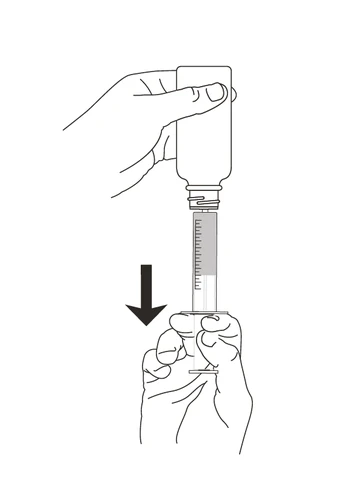 A hand holding a small bottle while the