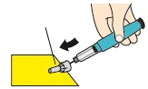 A hand holding a blue and gray medical device to insert a needle into a yellow surface following the direction of a black arrow