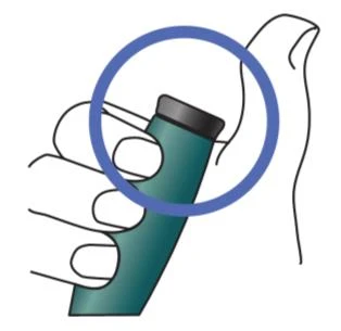 A hand holding a green cylindrical medical device with a blue circle highlighting the top part of the device